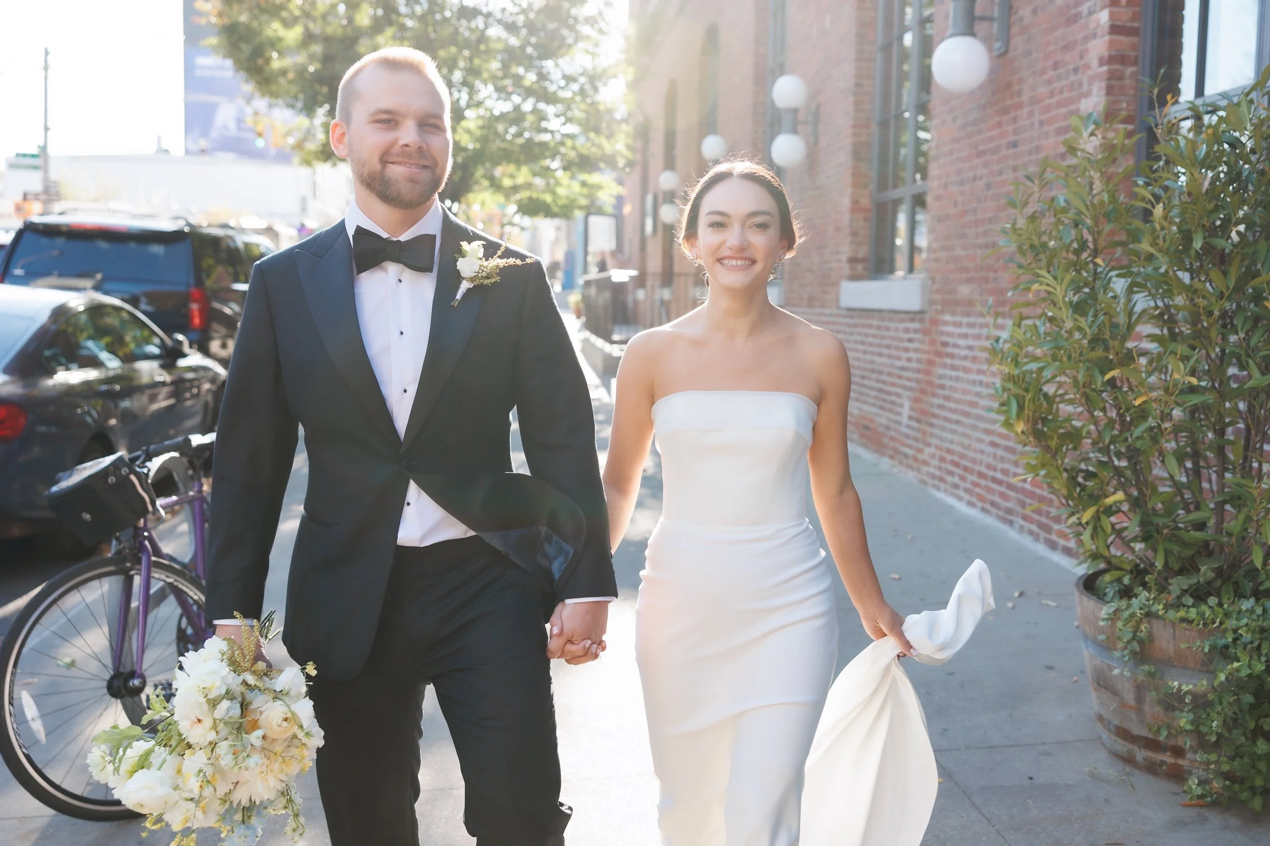  Couple smiles at the camera as they walk down the street 