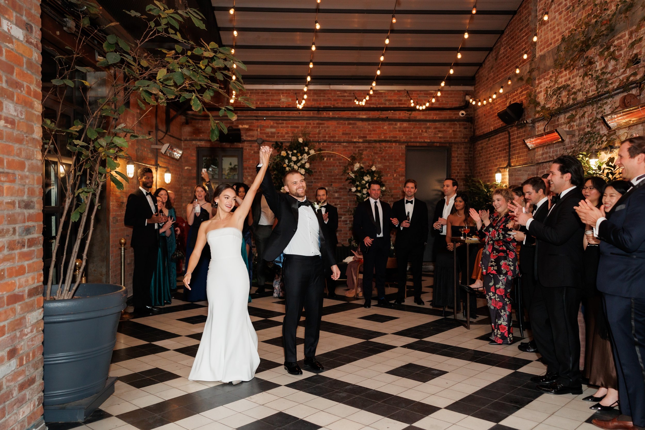  Couple celebrates as they enter their reception and their guests cheer them on 