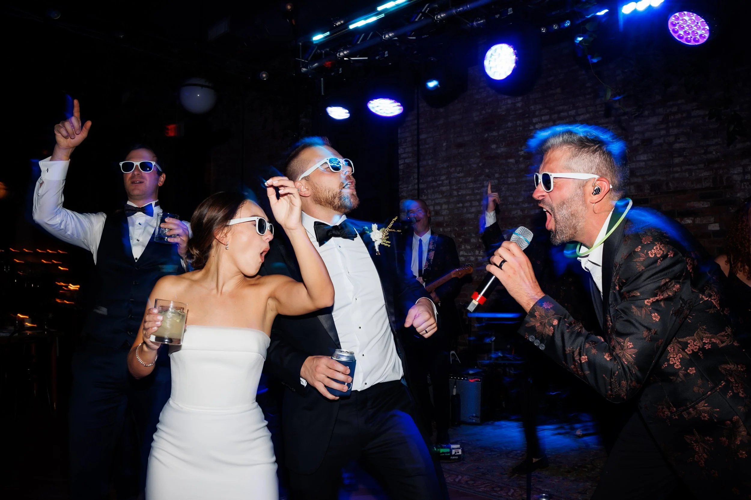  Couple sings along with band leader during their wedding reception 