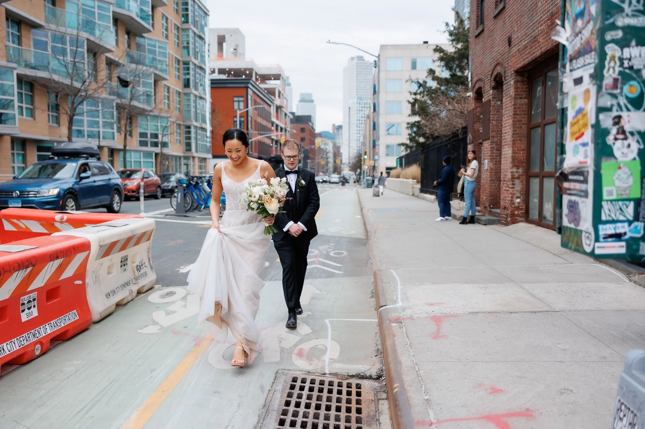 Couple walks across the street in Williamsburg Brooklyn on the way to the park on their wedding day