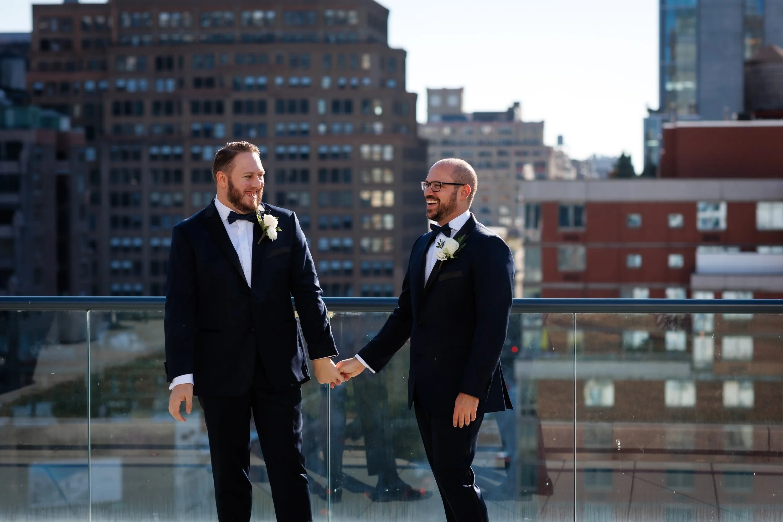 A wedding couple holding hands on a city rooftop 
