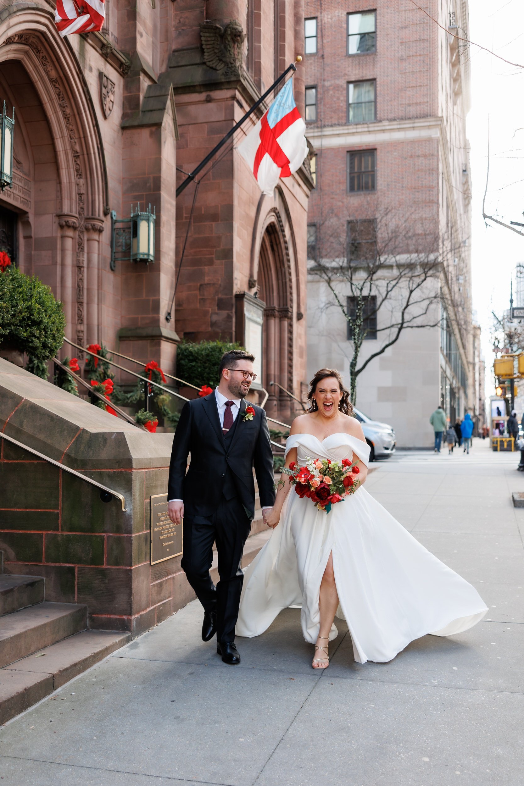 Newlyweds walking hand in hand down a city sidewalk