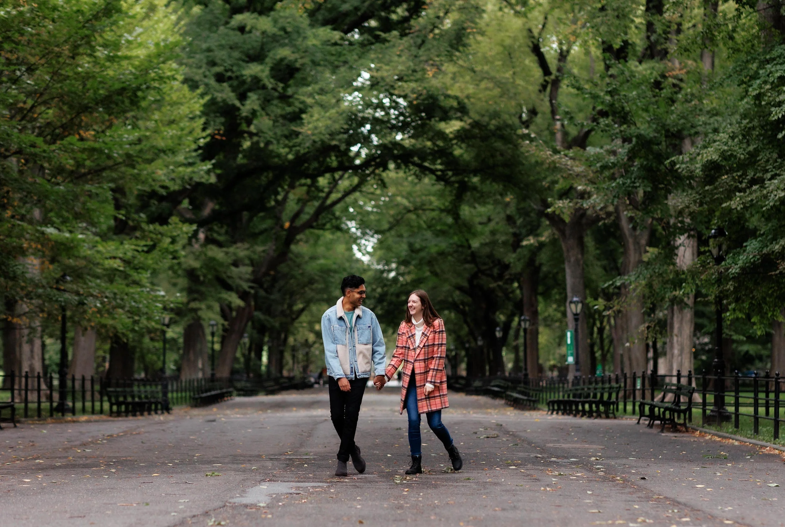 A couple holding hands and casually walking together in a park 