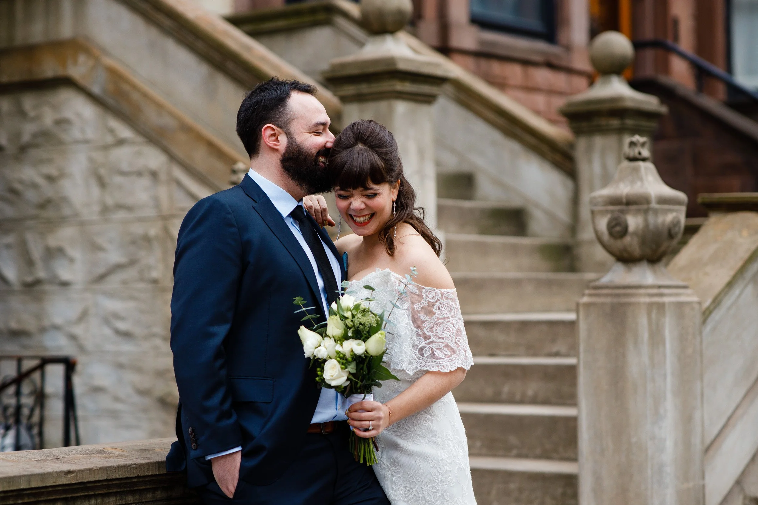 A newlywed kissing their partner's head as they laugh
