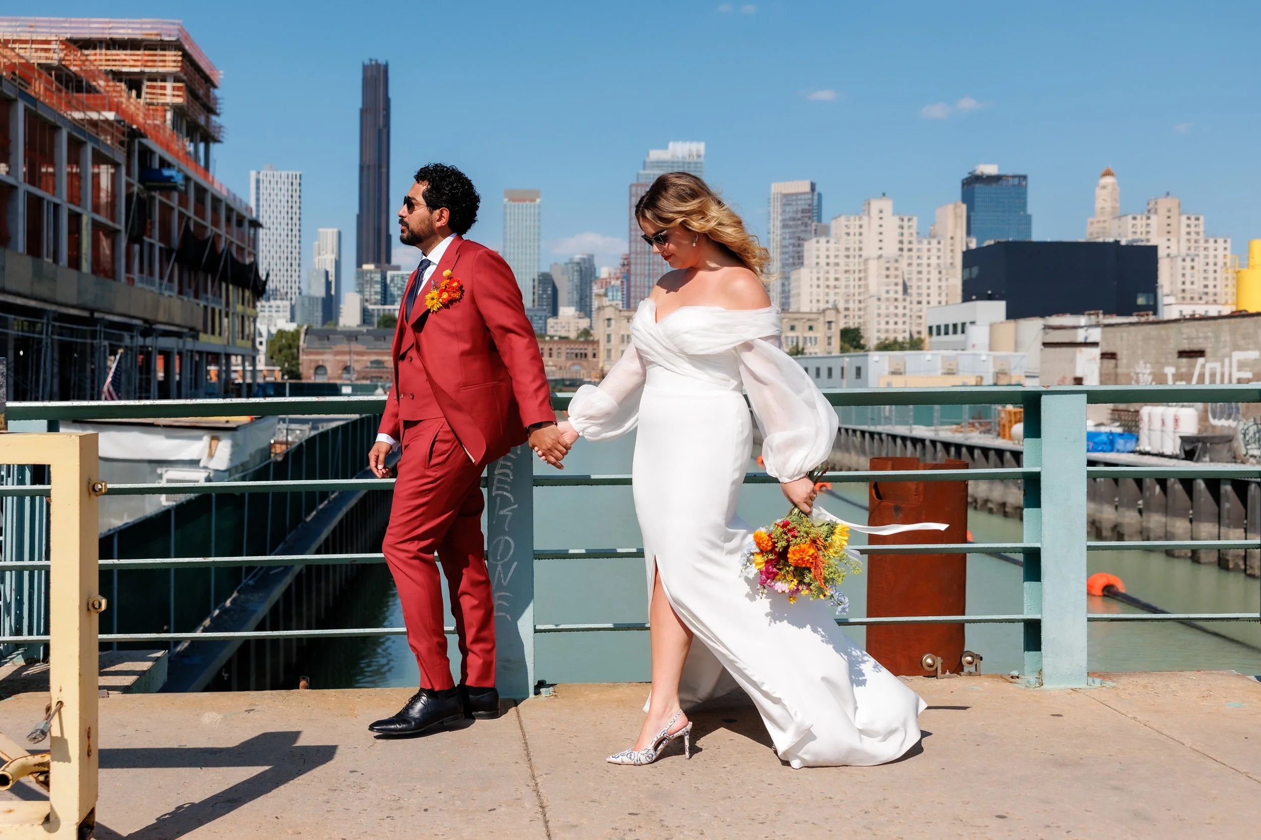 Newlyweds holding hands and walking onto a ferry 