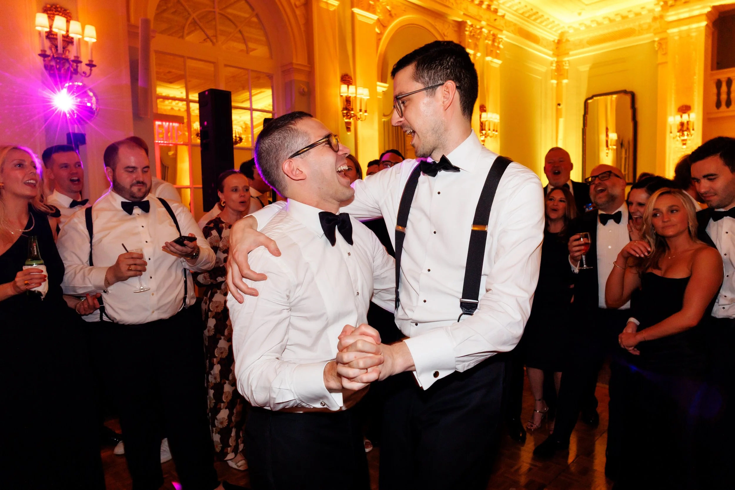 Newlyweds dancing as their wedding guests look on 