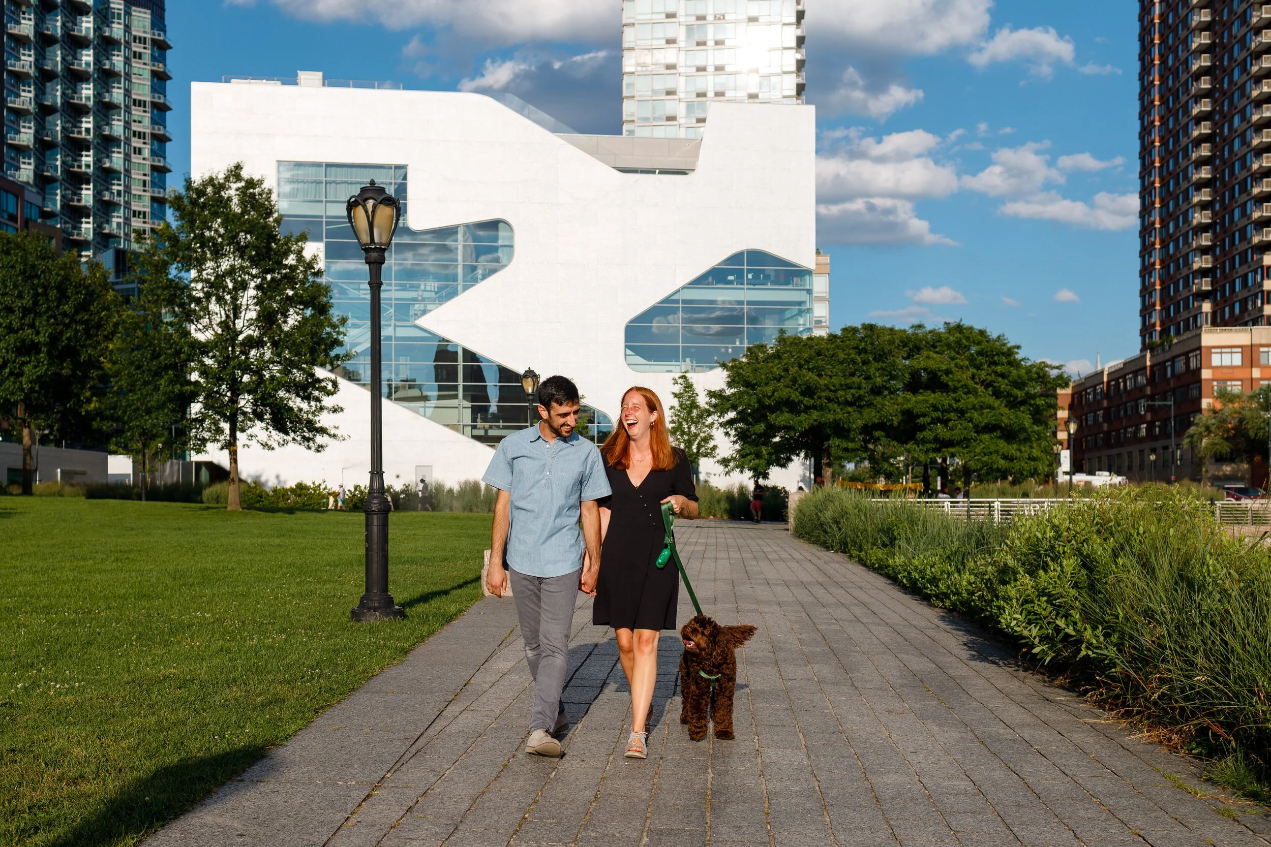 A couple walking along a brick path with their dog