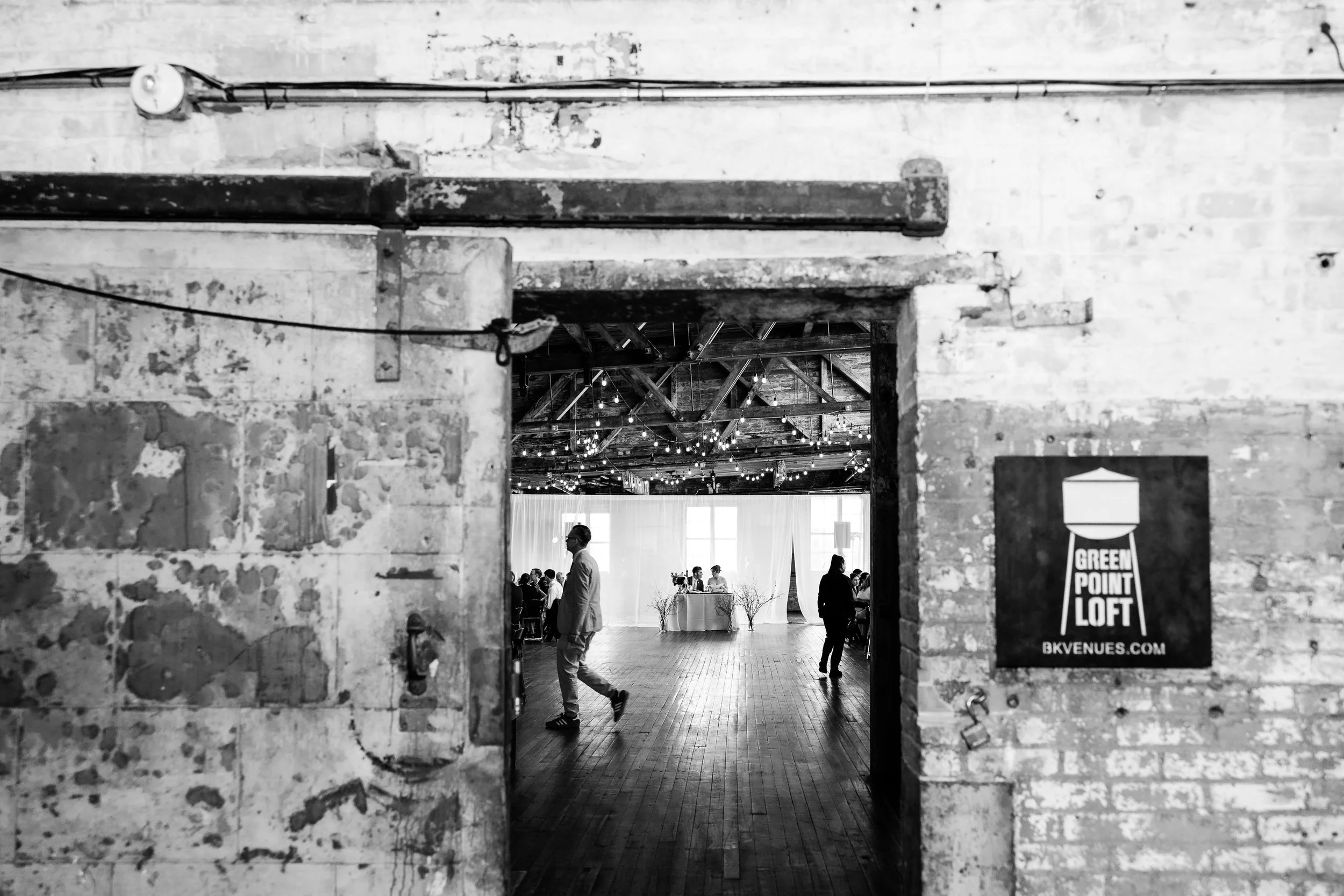 Looking through a sliding warehouse door into a wedding reception at Greenpoint Loft