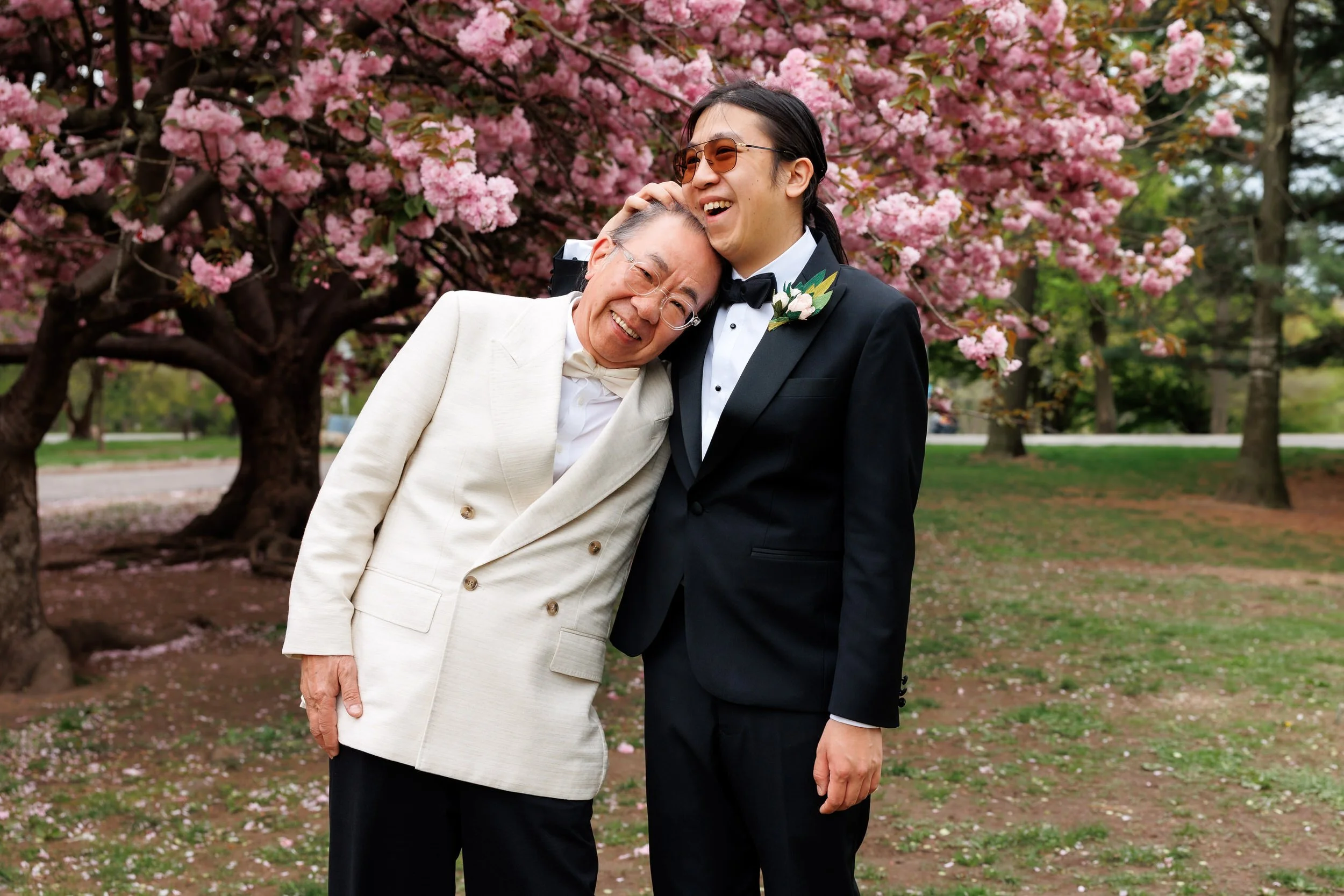 A newlywed hugging an older relative in a park