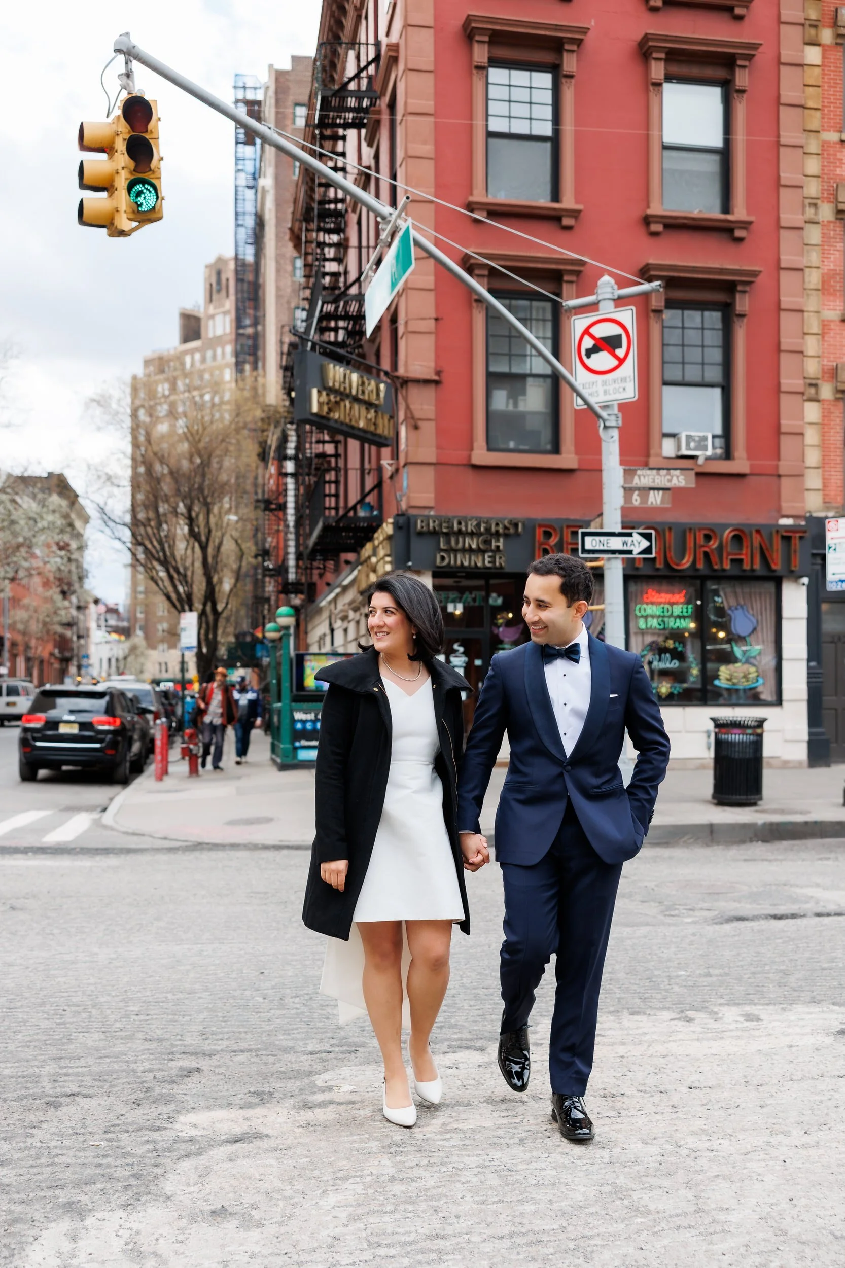 a wedding couple holding hands and crossing a city street 