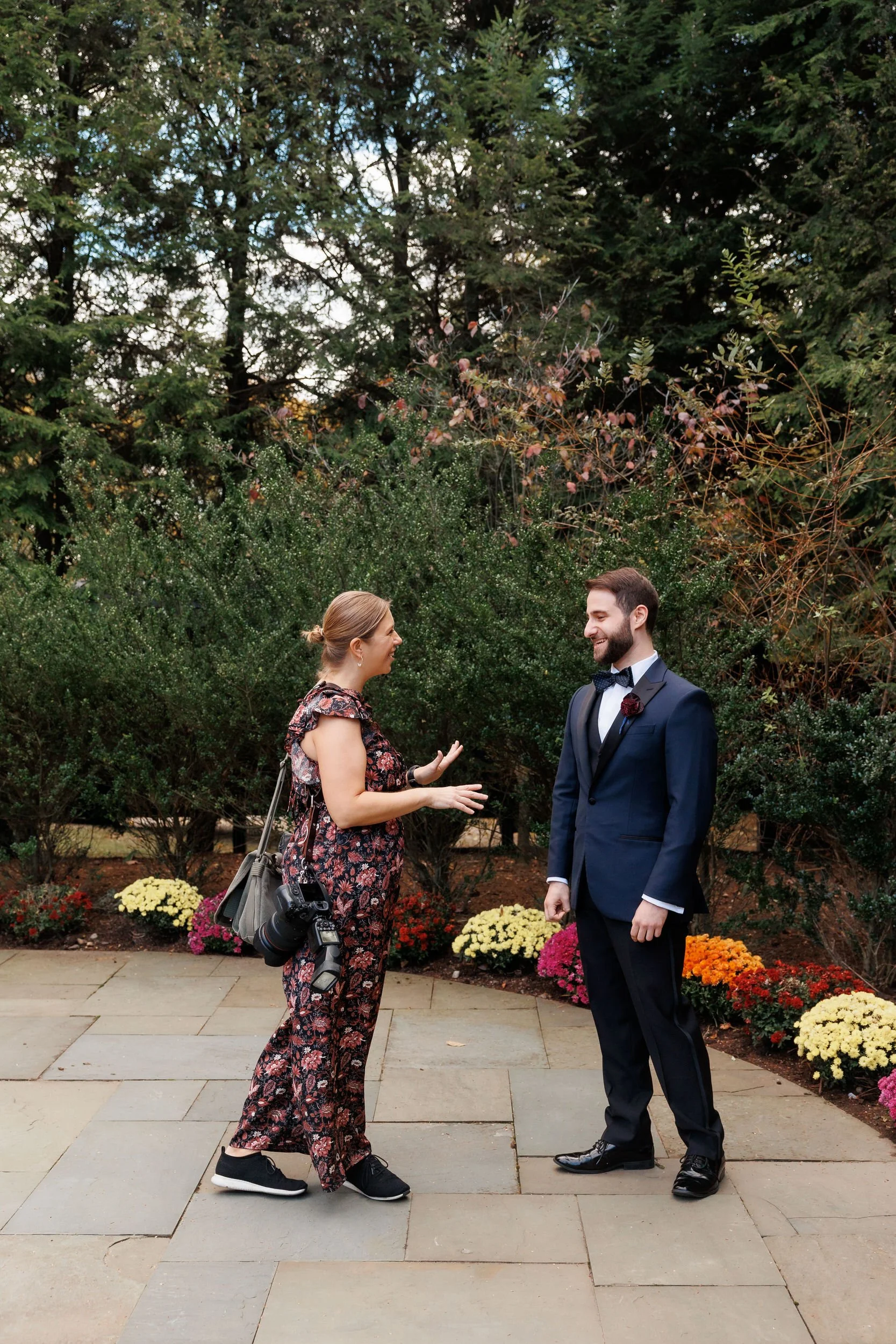 Sarah talking with a newlywed as they stand in a garden