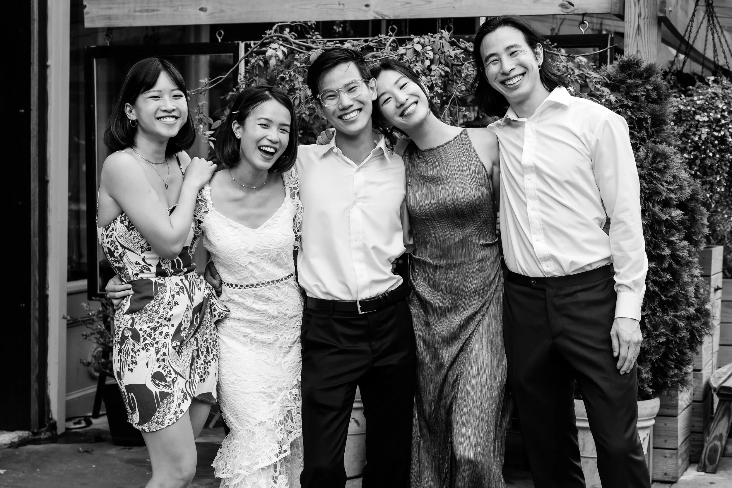 Newlyweds smiling as they stand with close friends 
