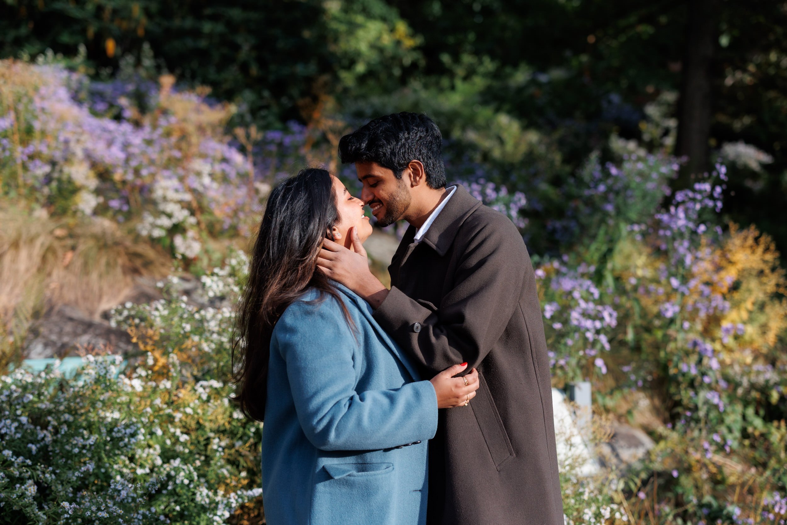 A person with their hands on their partner's face as they lean in to kiss them 