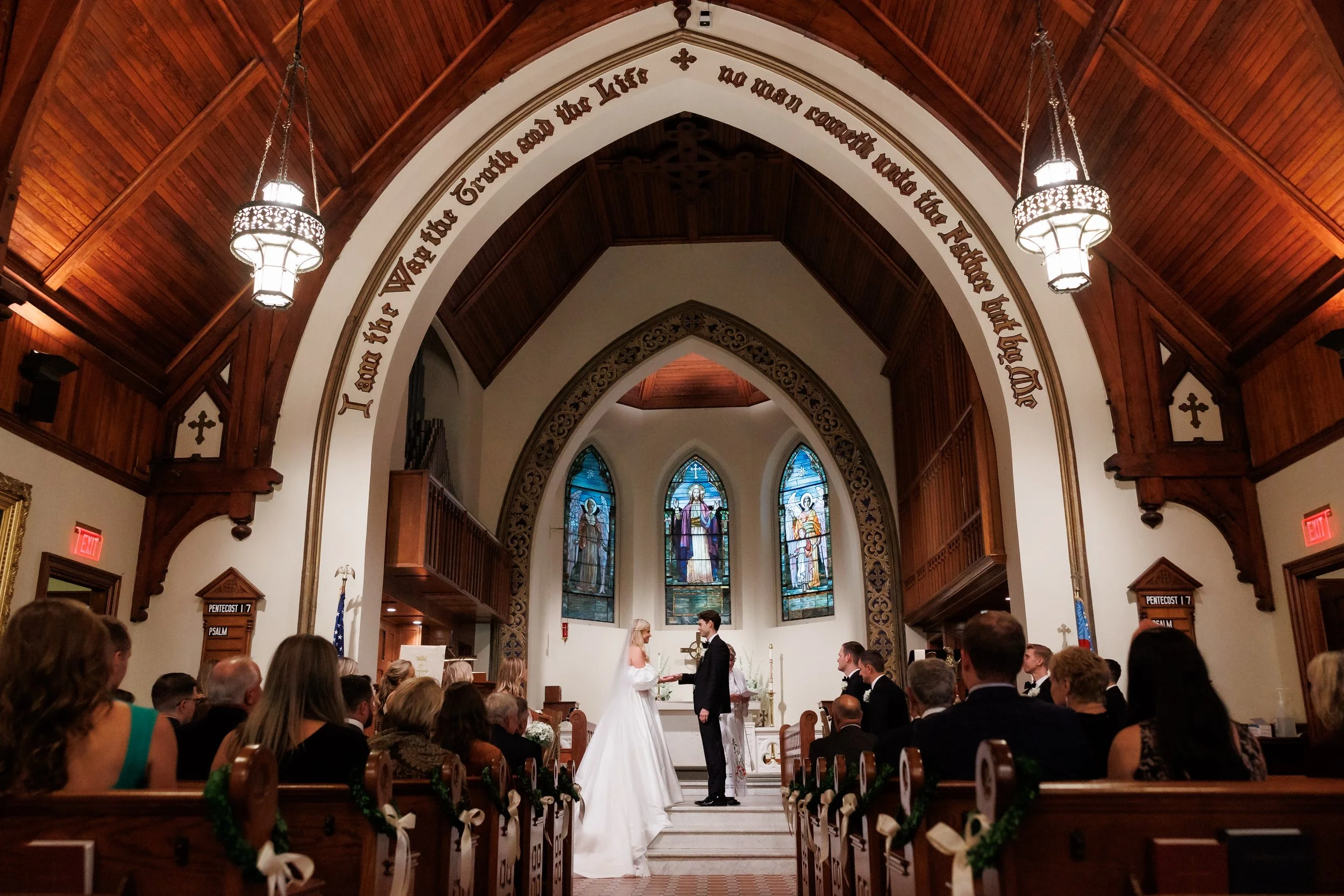 couple holds hands at the altar during their wedding ceremony at St Johns of Larchmont