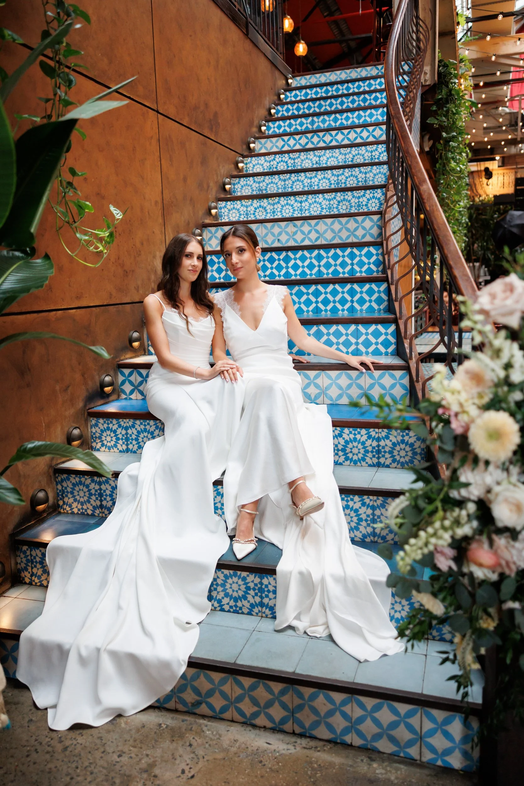 Newlyweds sitting on a colorful blue staircase together 
