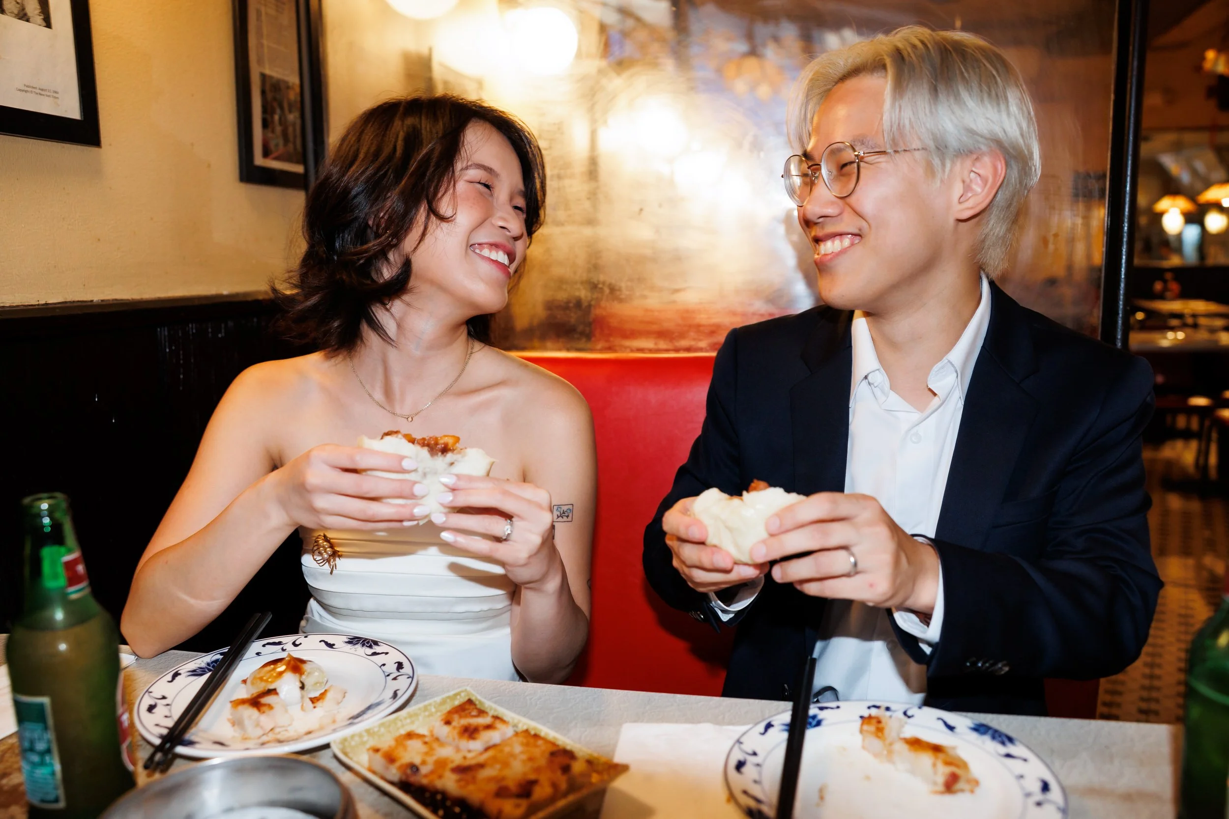 A couple smiling at each other as they sit at a restaurant and eat 