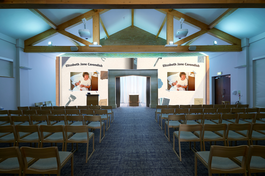 A conference or presentation room set up with rows of chairs, a stage with a screen displaying the name Elizabeth Jane Cavendish, and images of a woman holding a newborn. The room has a high wooden beam ceiling and a projector above the stage.