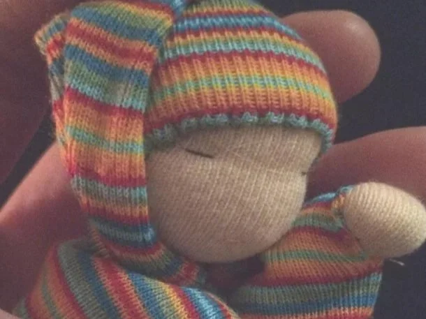 A Bábóg Project doll held in the hand.