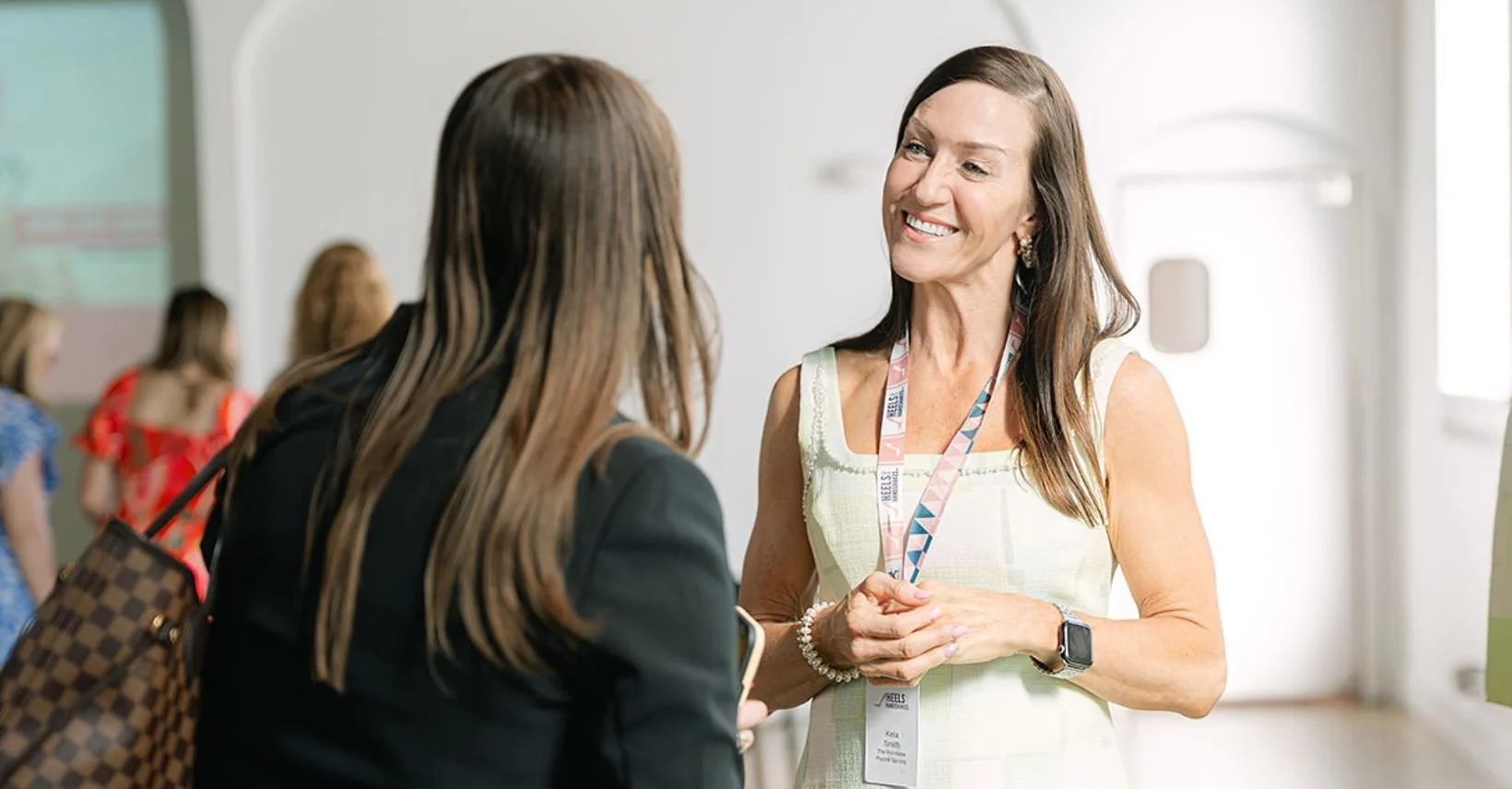 Two women having a conversation during a Heels & Handshakes networking event in Nashville.