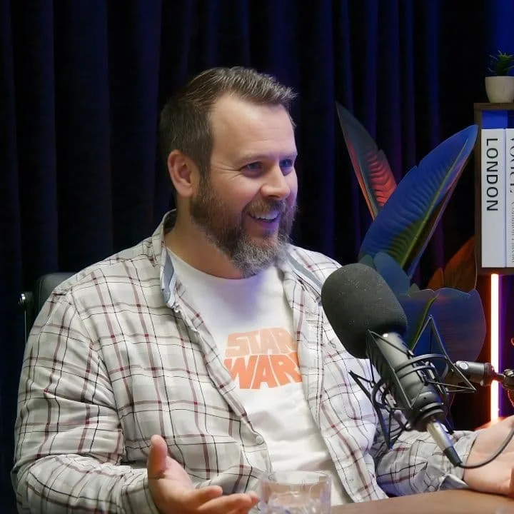 a man recording a podcast, sitting in front of a microphone