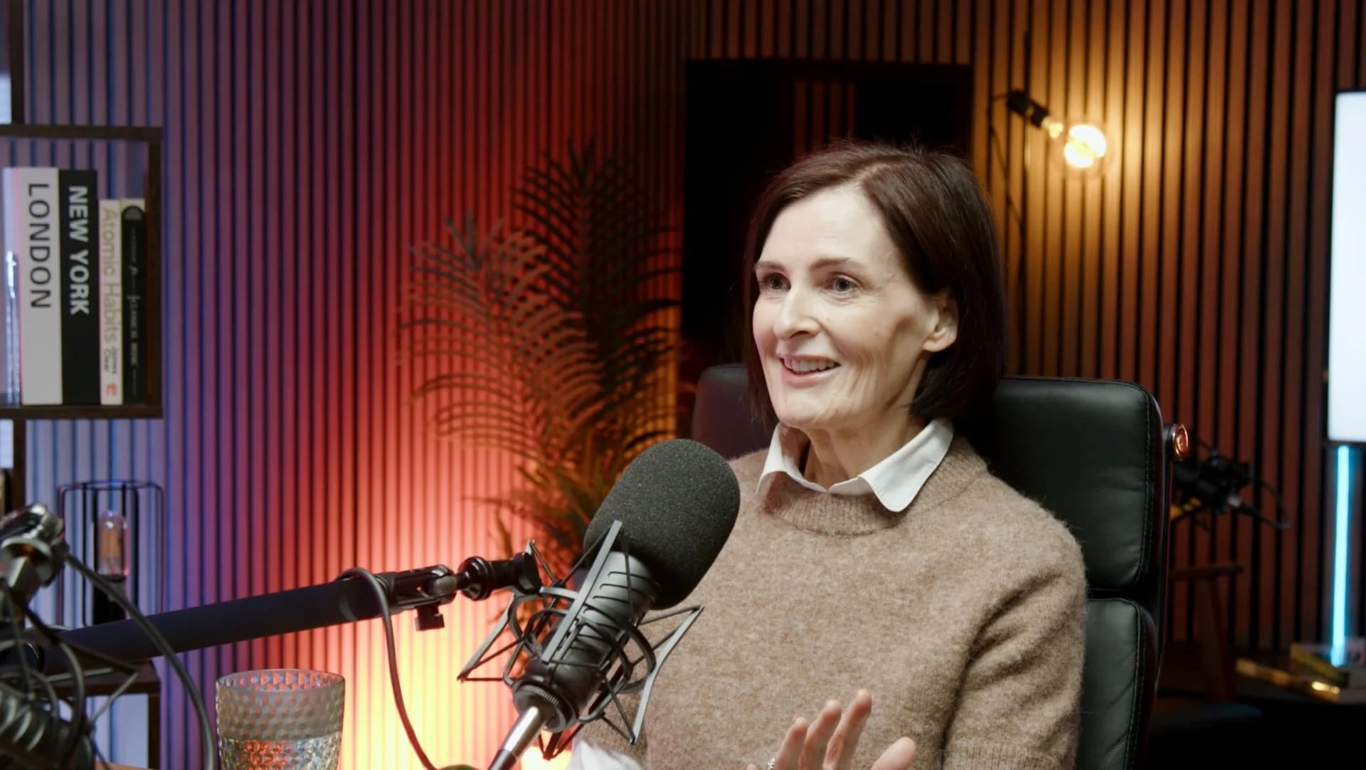 photo of a woman smiling while recording a podcast in the podcast studio glasgow