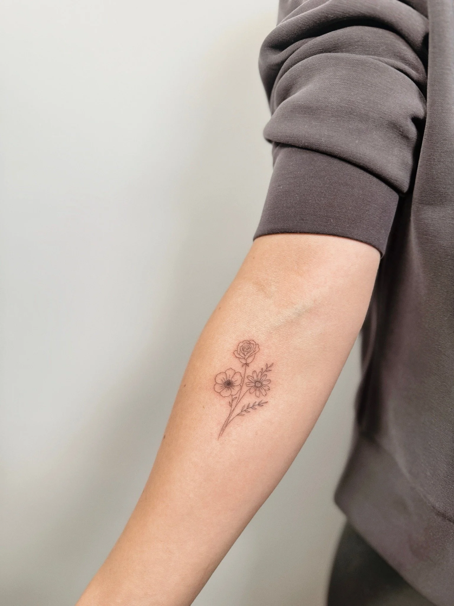 WISCONSIN FINE LINE FLORAL TATTOO ON FOREARM
