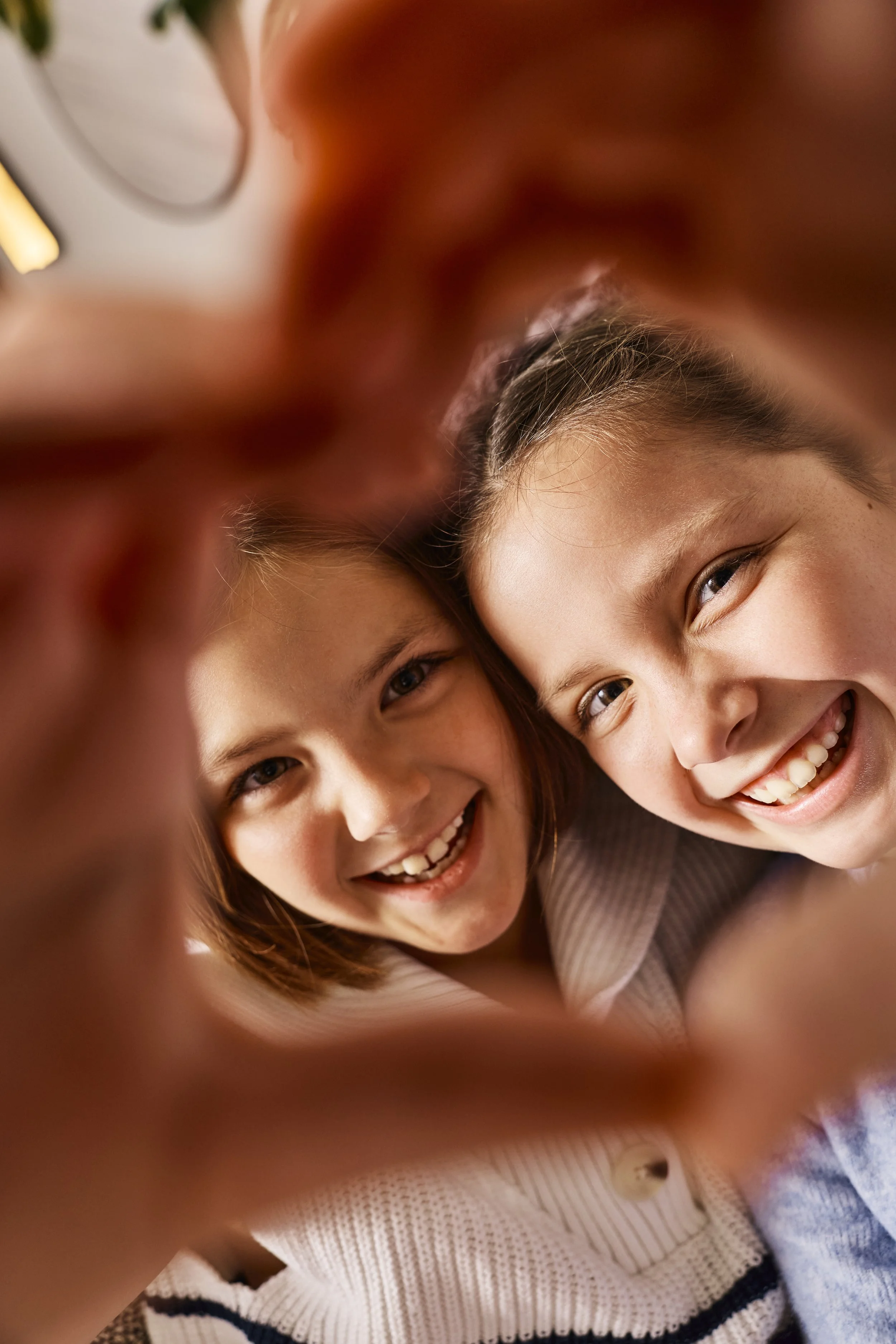 Close up lifestyle photo of two kids smiling and laughing framed by hands at The Phoenician Resort in Phoenix Arizona