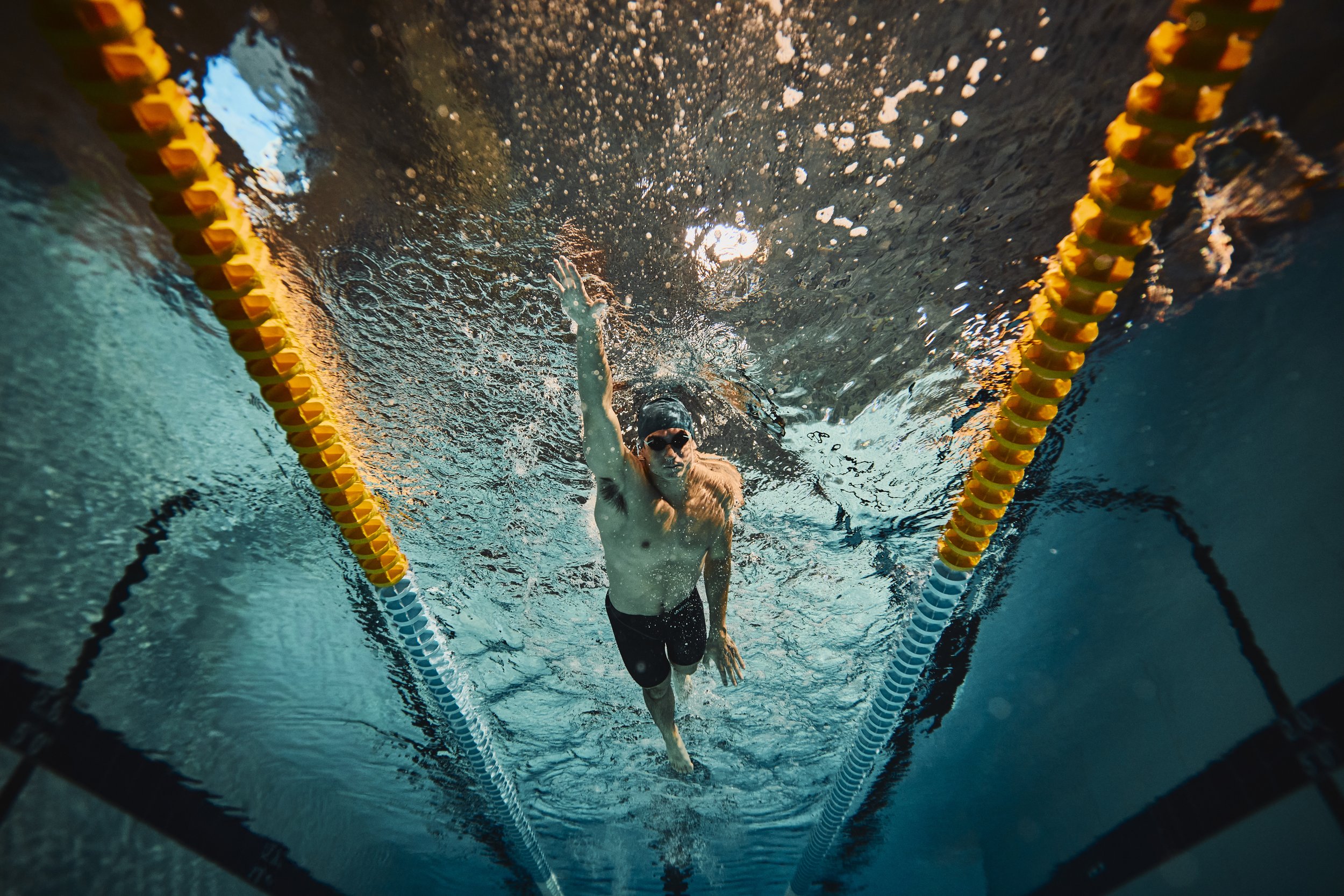 Cinematic underwater photo of swimmer training in lap pool with dynamic motion and light in Phoenix Arizona