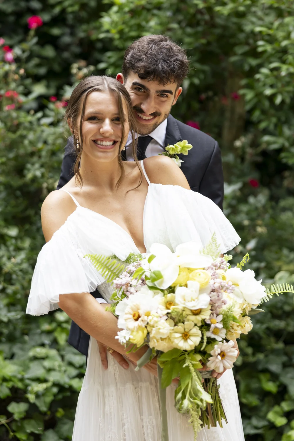 Bride holding a white and yellow garden bouquet by Bloom & Pour