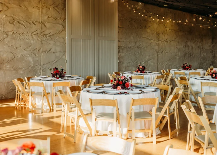 Reception tables with low red floral centerpieces
