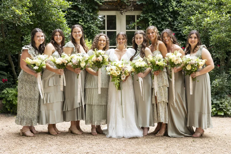 Bridesmaids in sage dresses holding matching bouquets