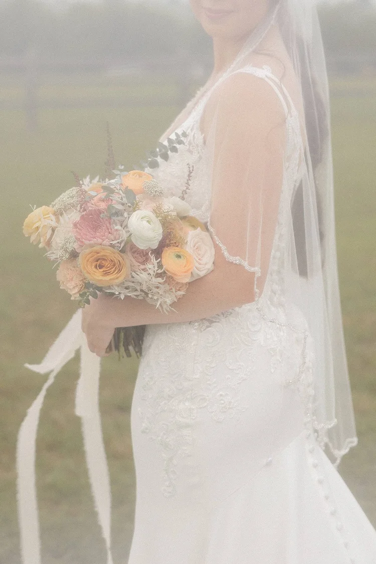 Close-up of a peach and blush garden bouquet with ribbon