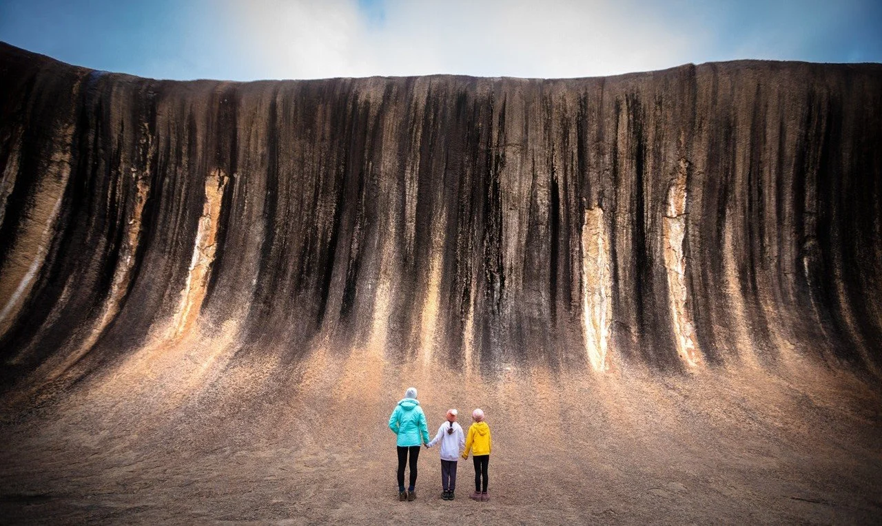 Family standing on top of Wave Rock, Hyden