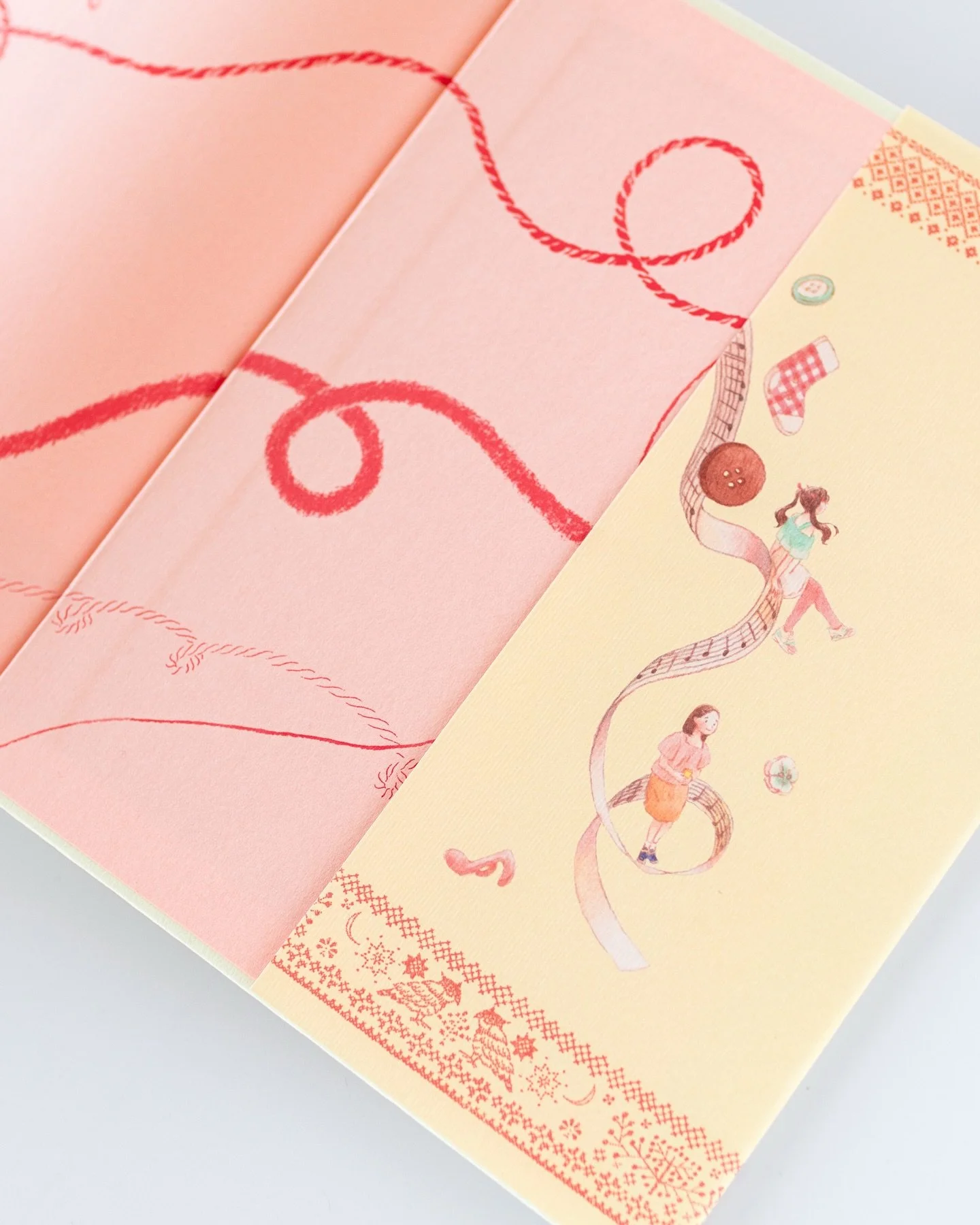 【おやすみ、悩み糸】紙の本の嬉しさが詰まった本になりました。
絵を担当させていただいた児童書『おやすみ、悩み糸』。
手に取った時に、紙の本の喜びをすごく感じる一冊だなあと、しみじみ嬉しく思っております。

特に本を開いた時がすごくかわいいので、ぜひ手に取ってご覧いただけると、とても嬉しいです。

表紙をめくって、パッと目に飛び込んでくる綺麗なピンク色。
見返しには、赤色のいろんな「糸」がくるりくるりとしています。
そでの絵と相まって、これがすごく可愛いのです&hellip;&hellip;。
（