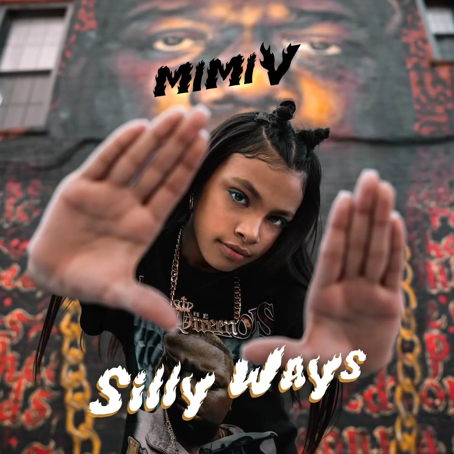 Young woman with dark hair styled in two buns holds up her hands in front of a mural featuring a face with glowing eyes. Text on the image reads 'MIMIV' at the top and 'Silly Ways' at the bottom.