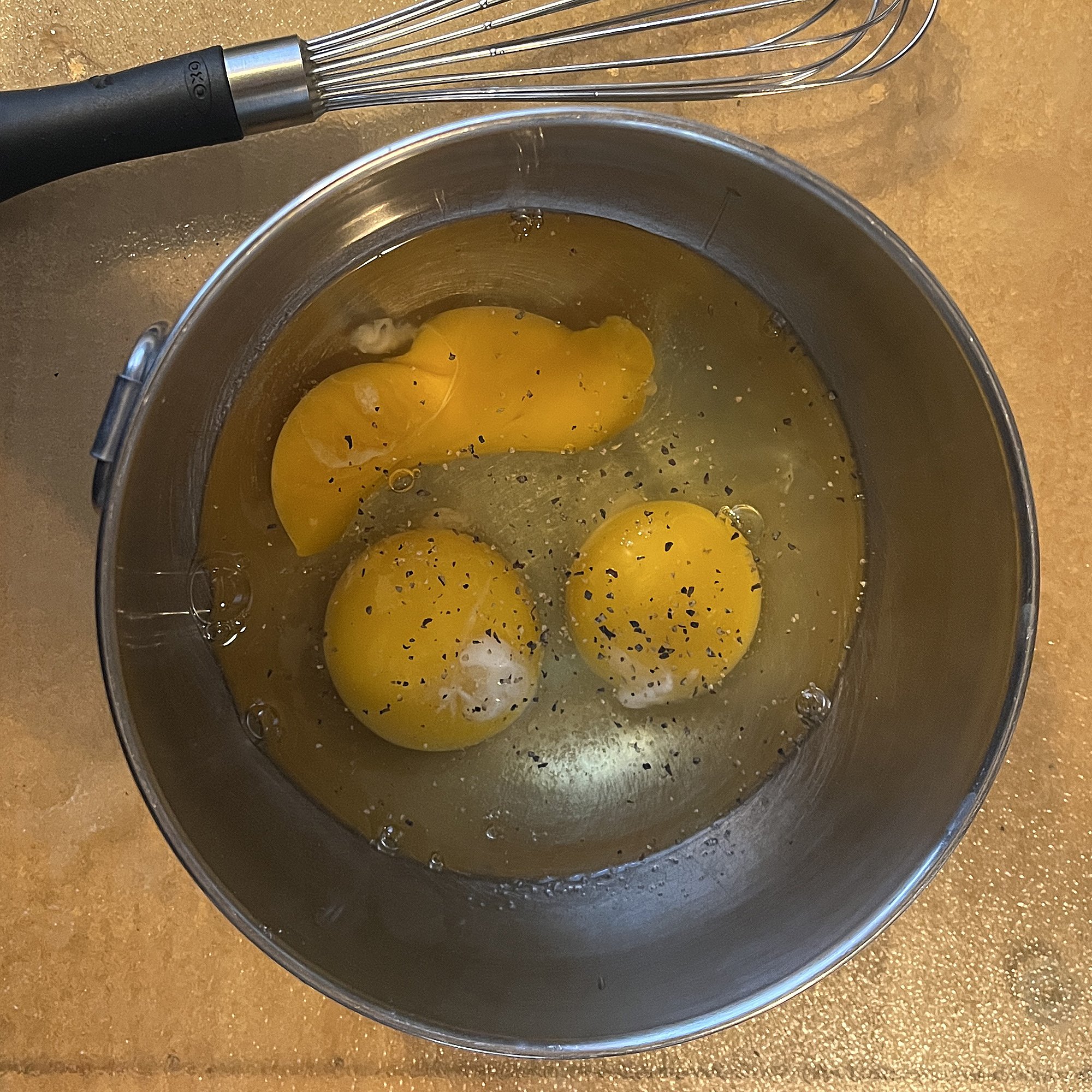 Break three eggs at a time into a bowl.