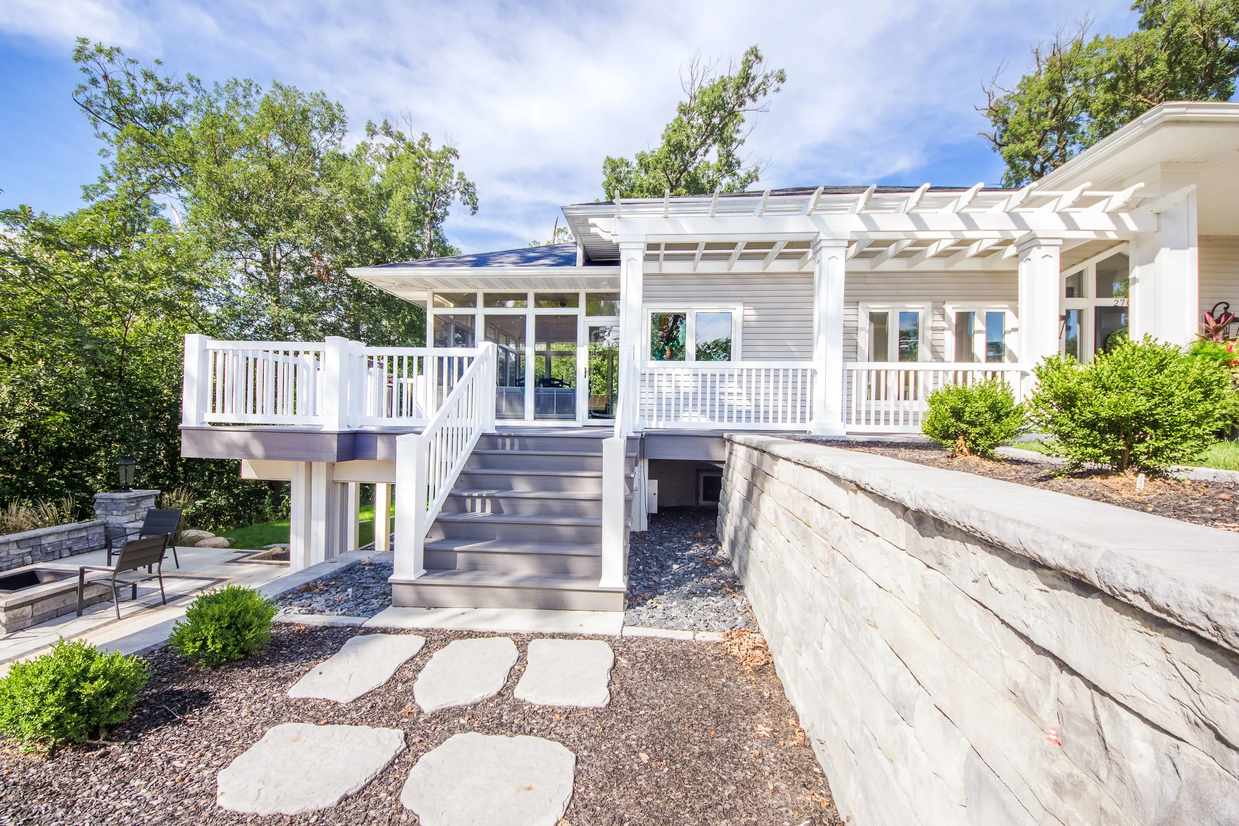 composite deck on home with white pergola