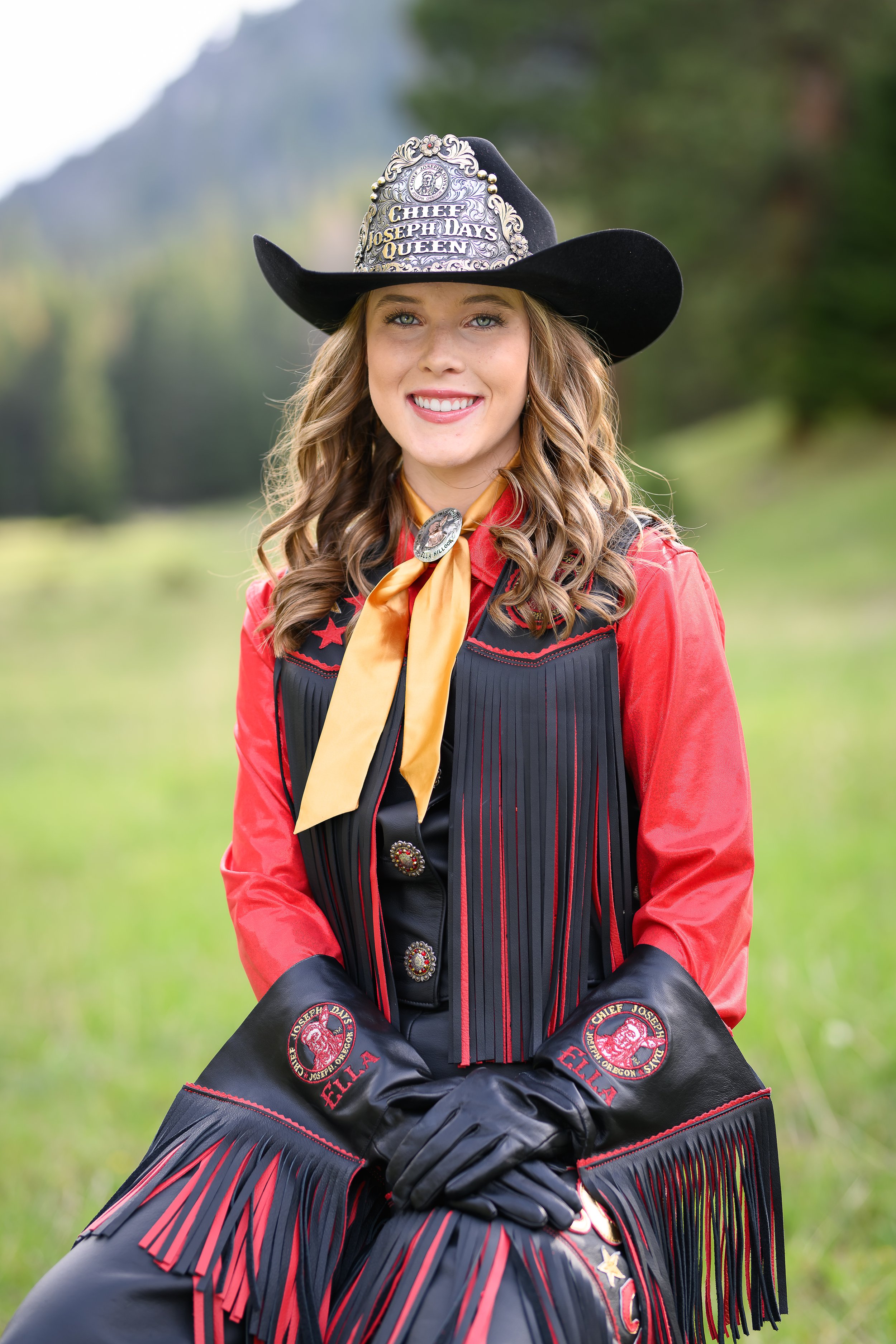 Woman dressed as a rodeo queen with a cowboy hat, blue shirt, and fringed vest.