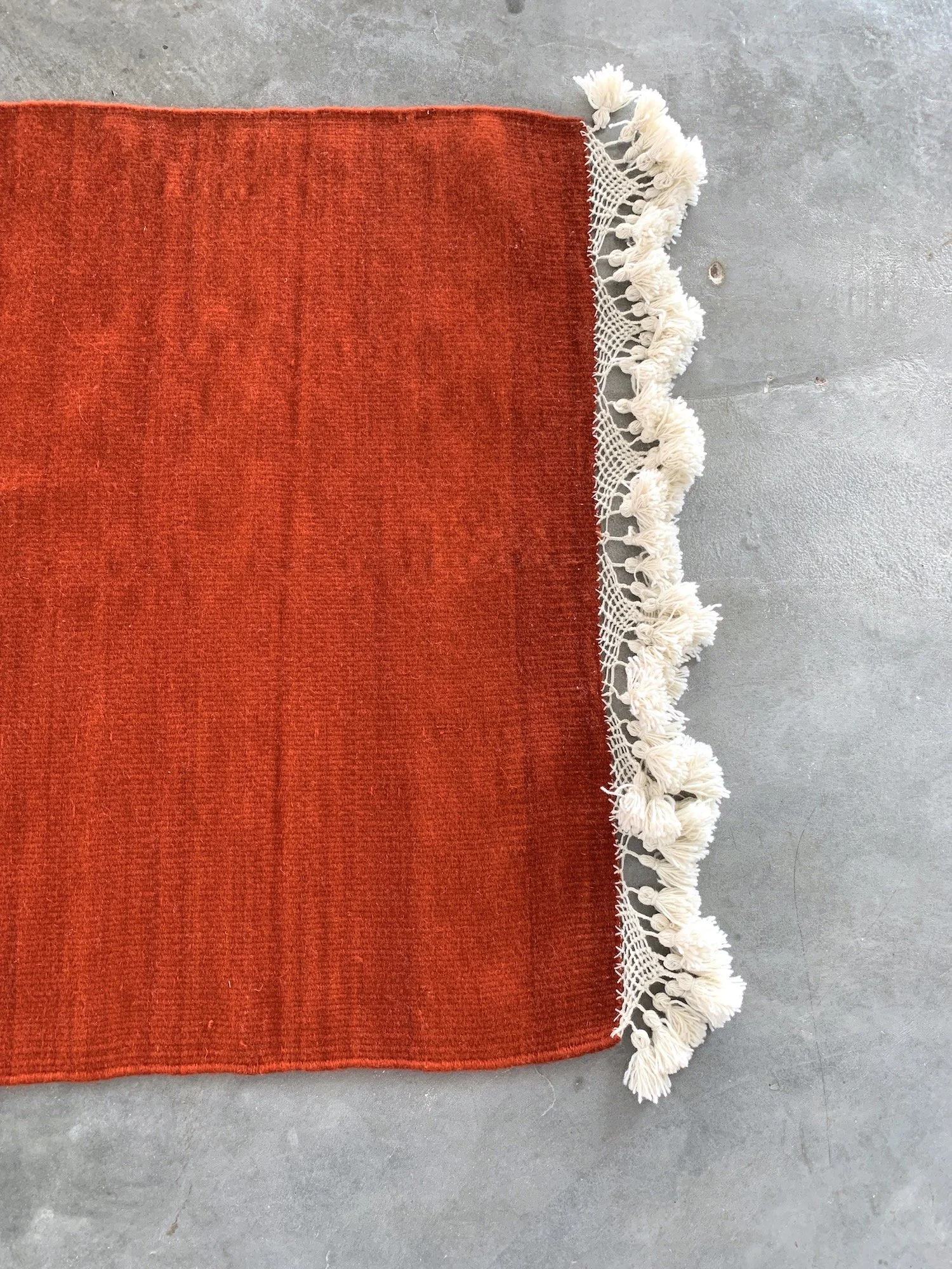 Mexchic handwoven wool rug with natural dyes and pom pom fringe made in teotitlan del valle oaxaca, the best shopping in oaxaca, guide clothing homewares boho tulum style contemporary Mexican design