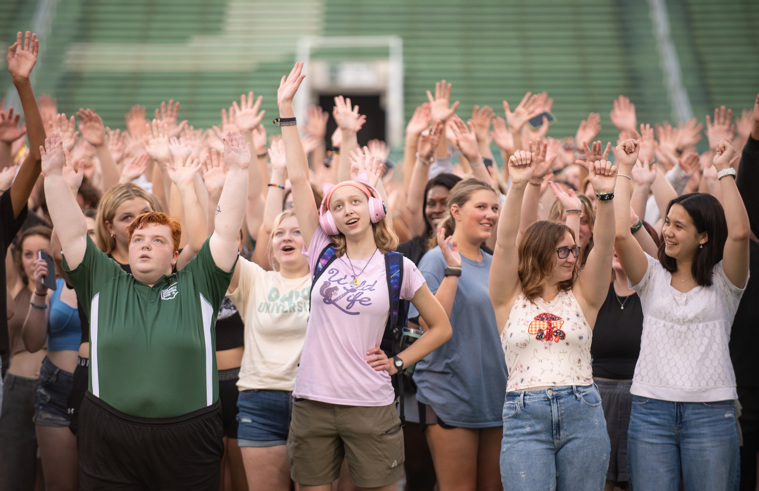 First year Ohio University students raise their hands during their class picture. Taken for Ohio University Communications and Marketing.
