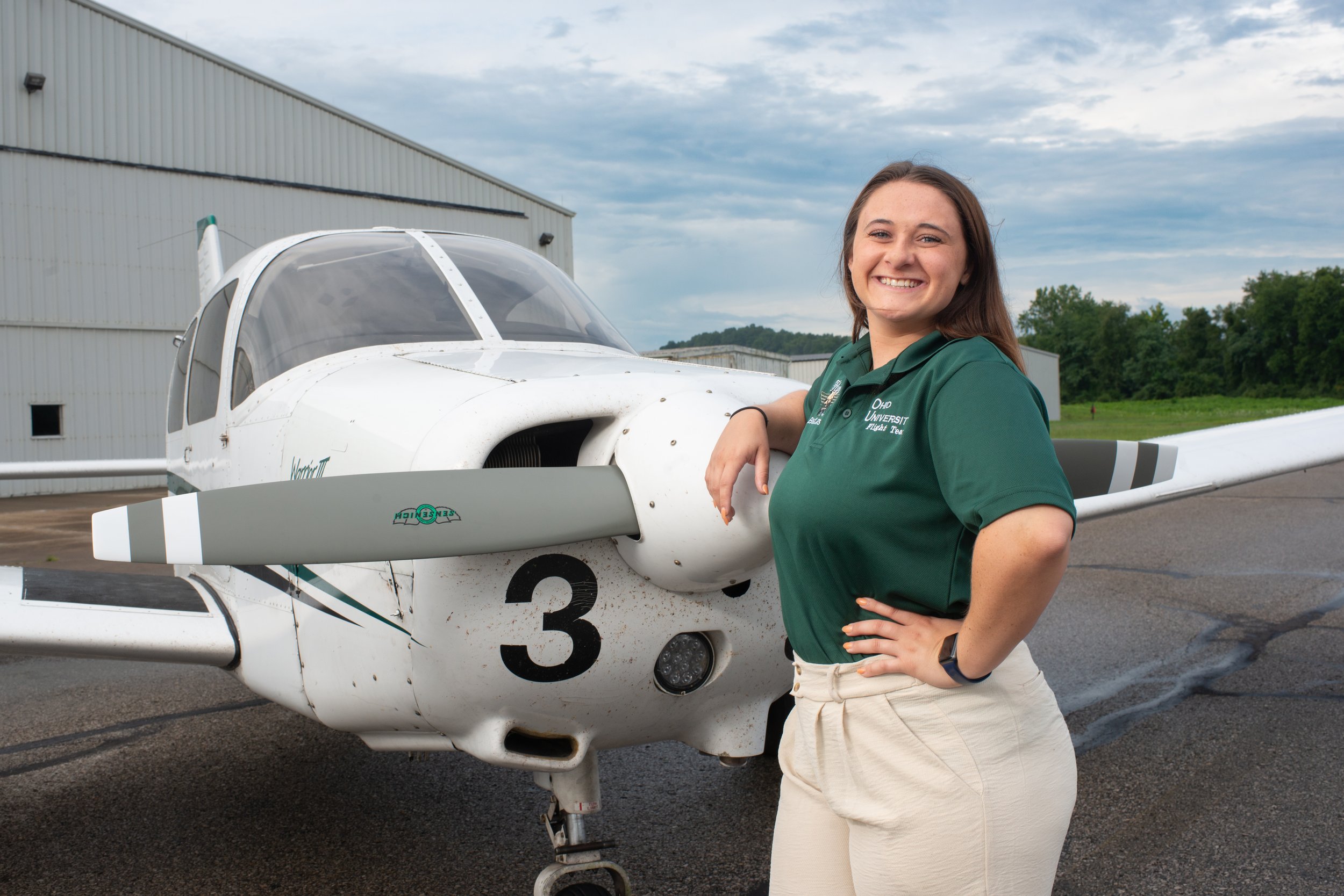 Dianna Sprague, a senior in Ohio University's Aviation Program, poses for a portrait in front of one of the school's aircraft in Athens, Ohio on August 7, 2023.