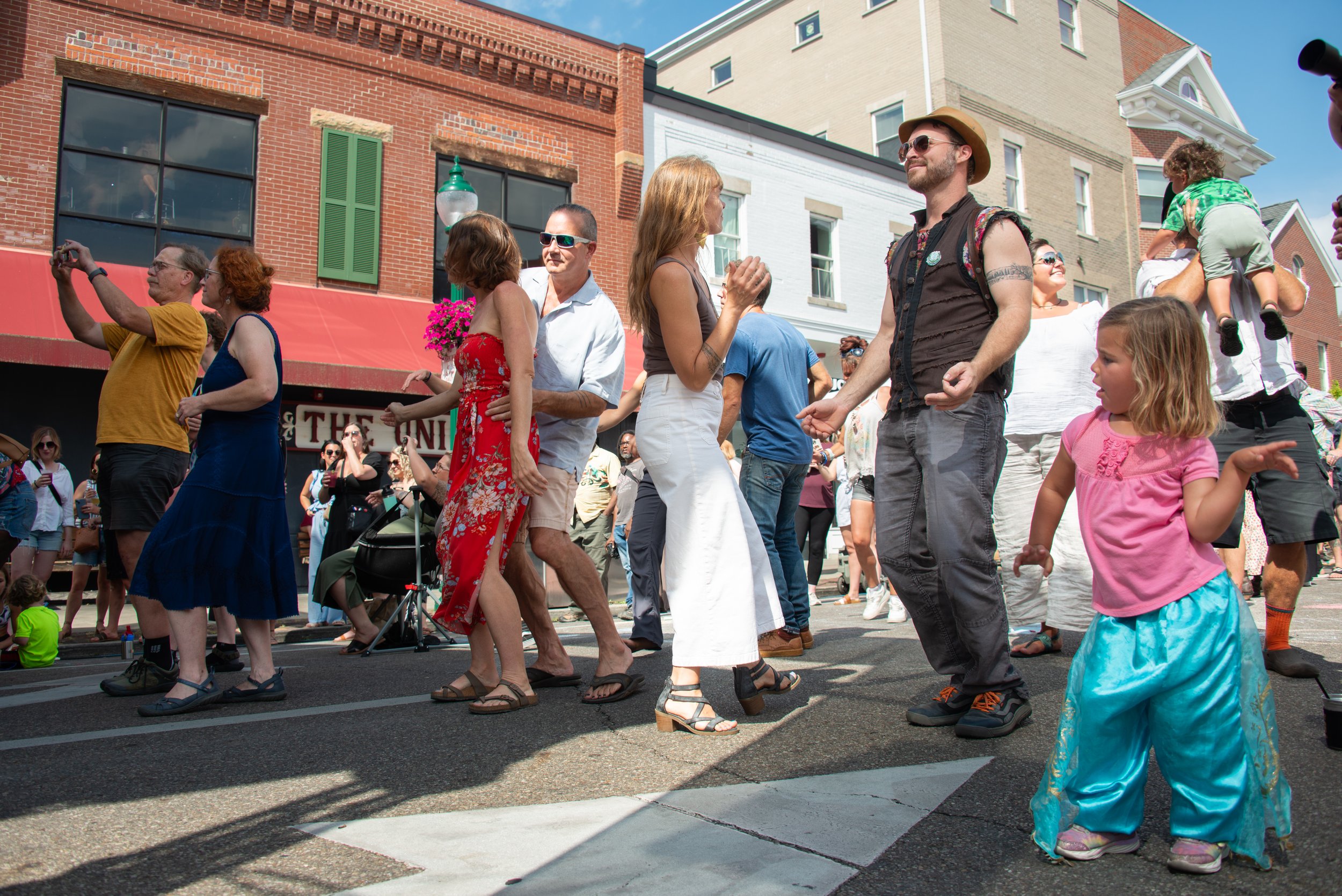 Festival goers dance to the Hill Spirits during the Athens Community Arts and Music Festival on Aug. 12, 2023 in Athens, Ohio. The Athens Community Arts and Music Festival is held every summer in Athens, giving local musicians a chance to play for th
