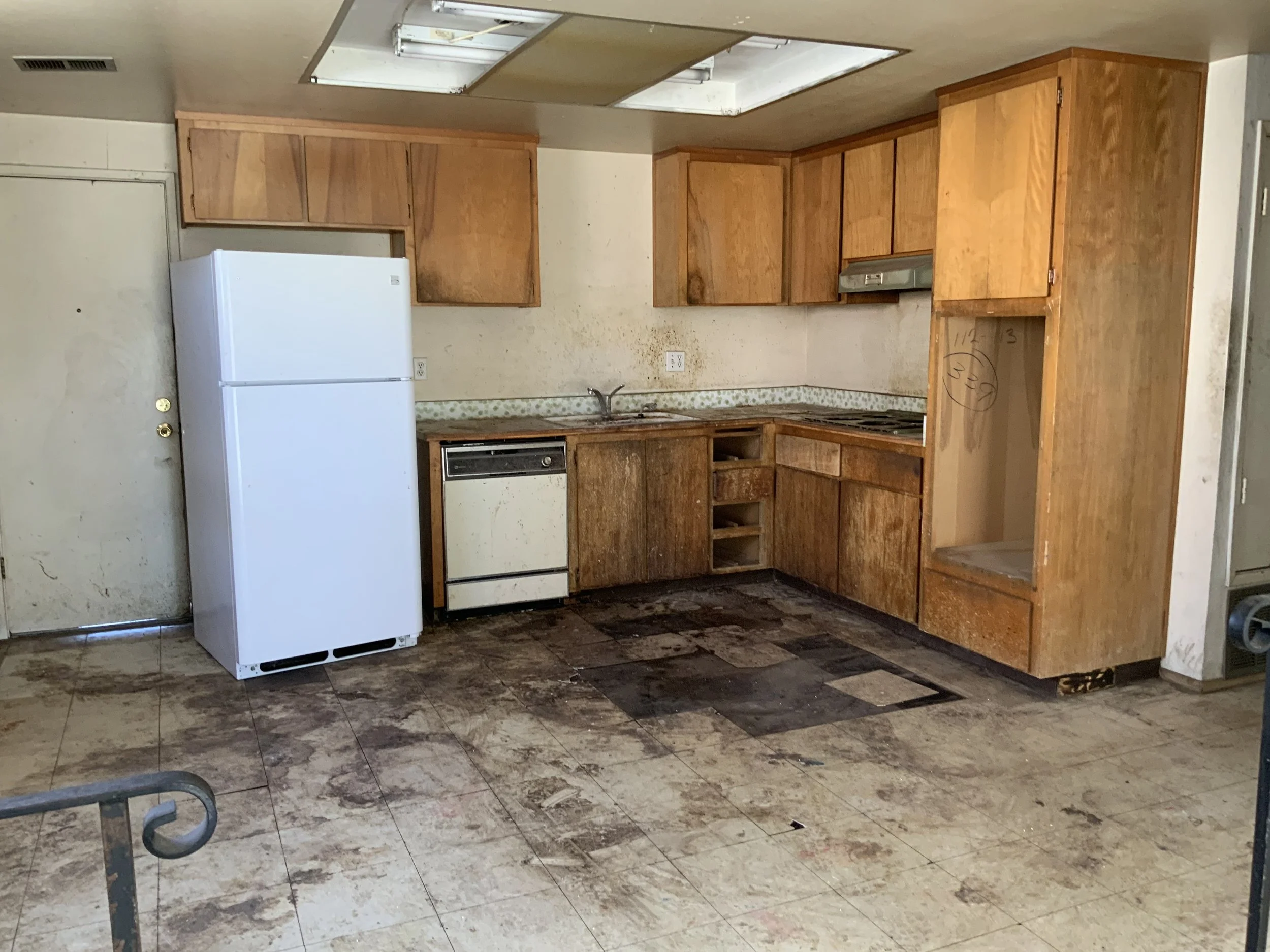 Antioch Hoarder house clean out in Kitchen, completed stage of house clean out all trash, debris removed from kitchen an empty space with refrigerator and wood cabinets. Total house clean out complete.