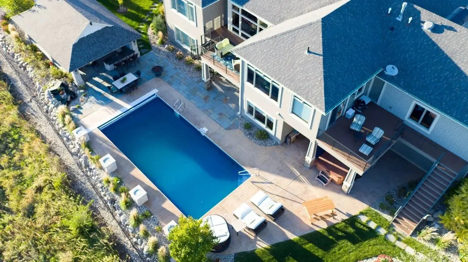 a drone aerial view of a backyard with landscaping and a pool
