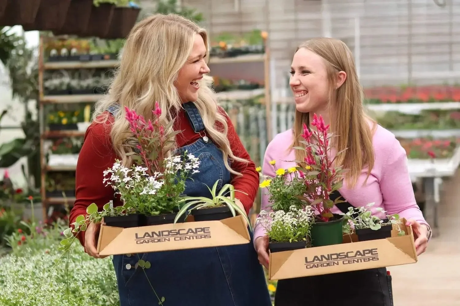 two ladies holding plants they planted during a workshop