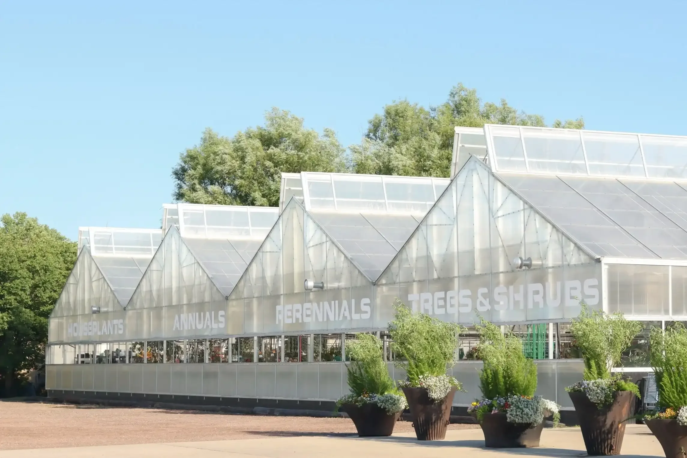 the outside of the greenhouses labeled with "houseplants", "annuals", "perennials", "trees & shrubs"