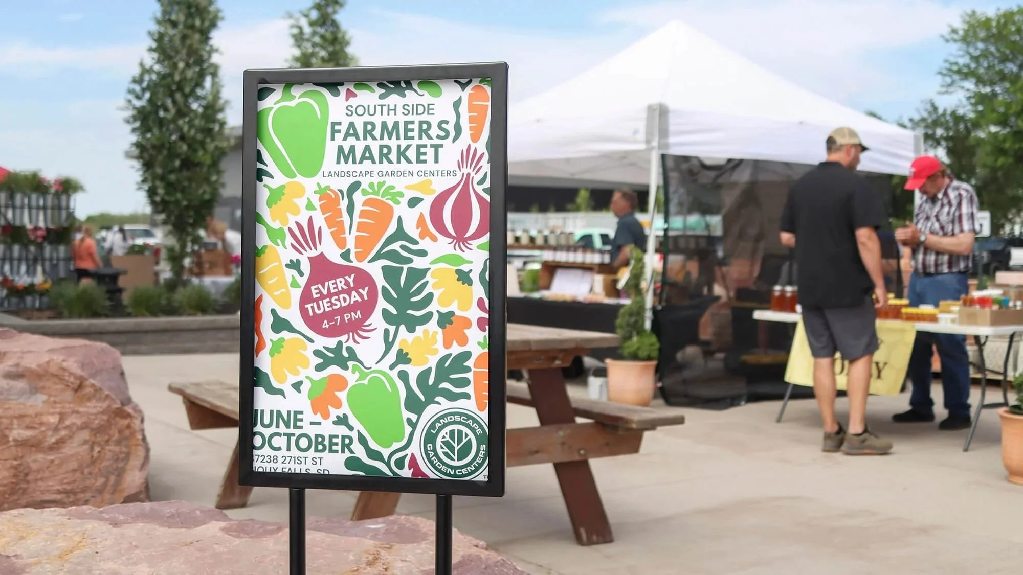 sign promoting the south side farmers market with vegetables in the background