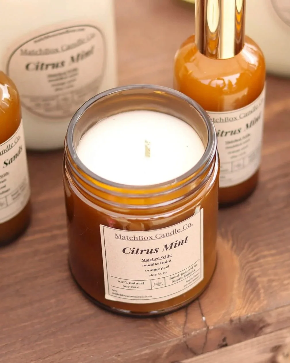 a citrus mint candle with other citrus mint products behind it
