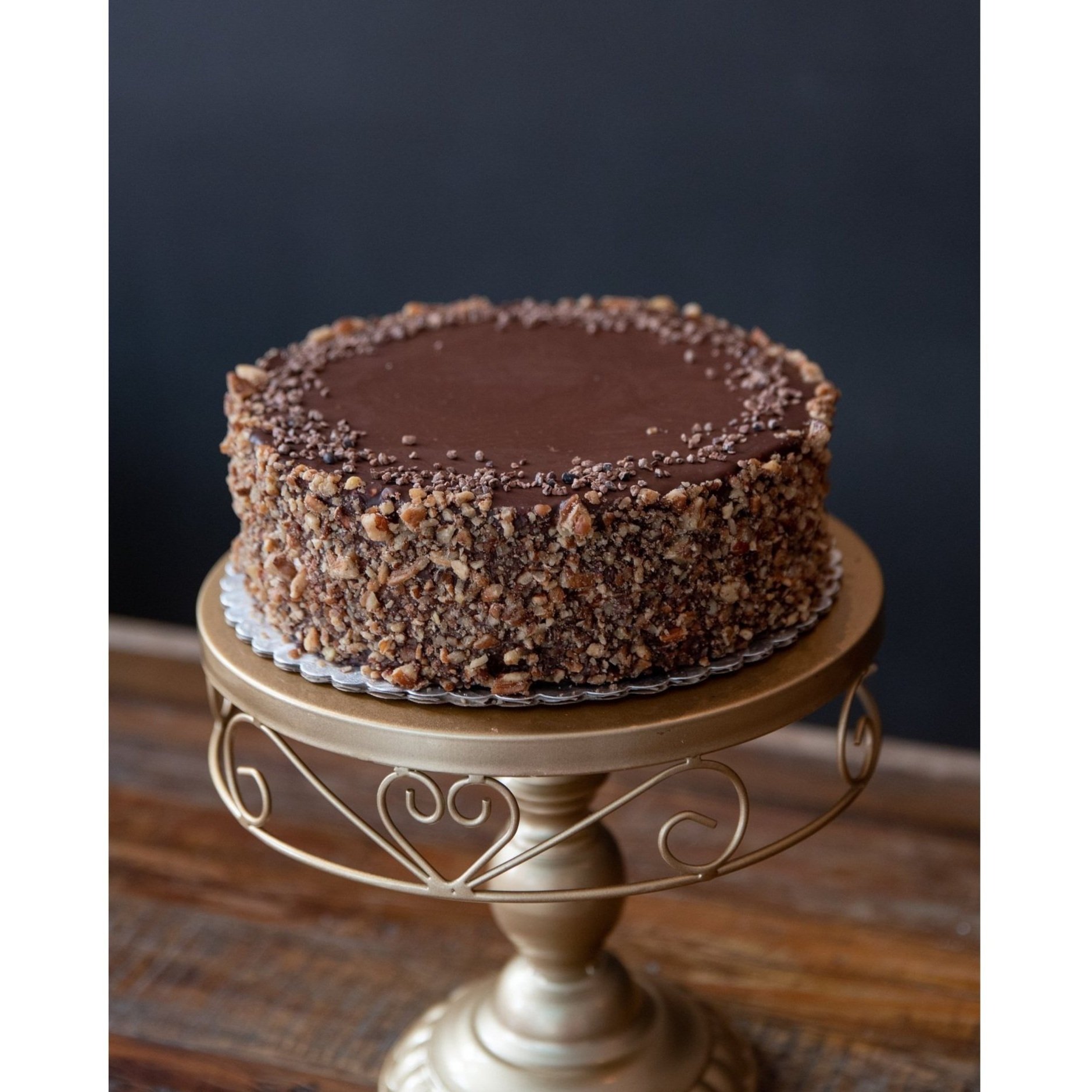 TUXEDO - Chocolate cake with chocolate and vanilla mousse, layered with raspberry jam. Polished with ganache and coated with pecans.