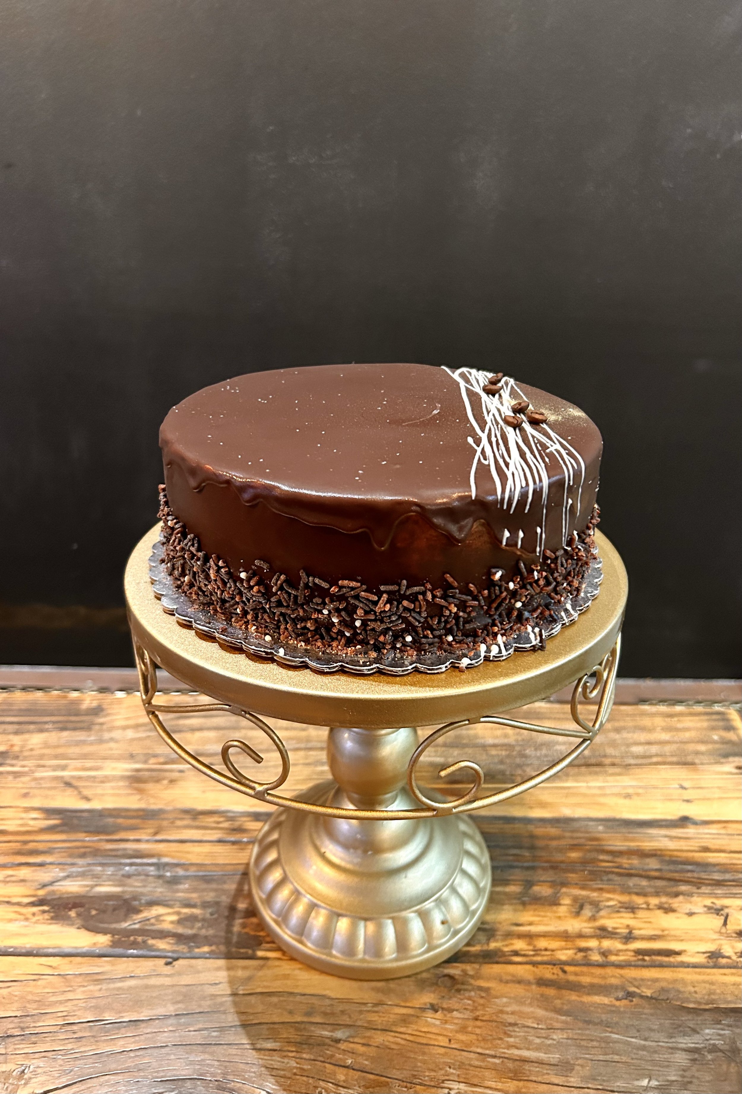 ESPRESSO CAKE: Chocolate cake with homemade espresso filling. Polished with dark chocolate ganache and garnished with chocolate sprinkles.